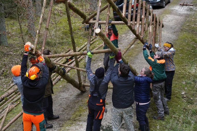 Zwei Männer bauen einen Hochsitz.